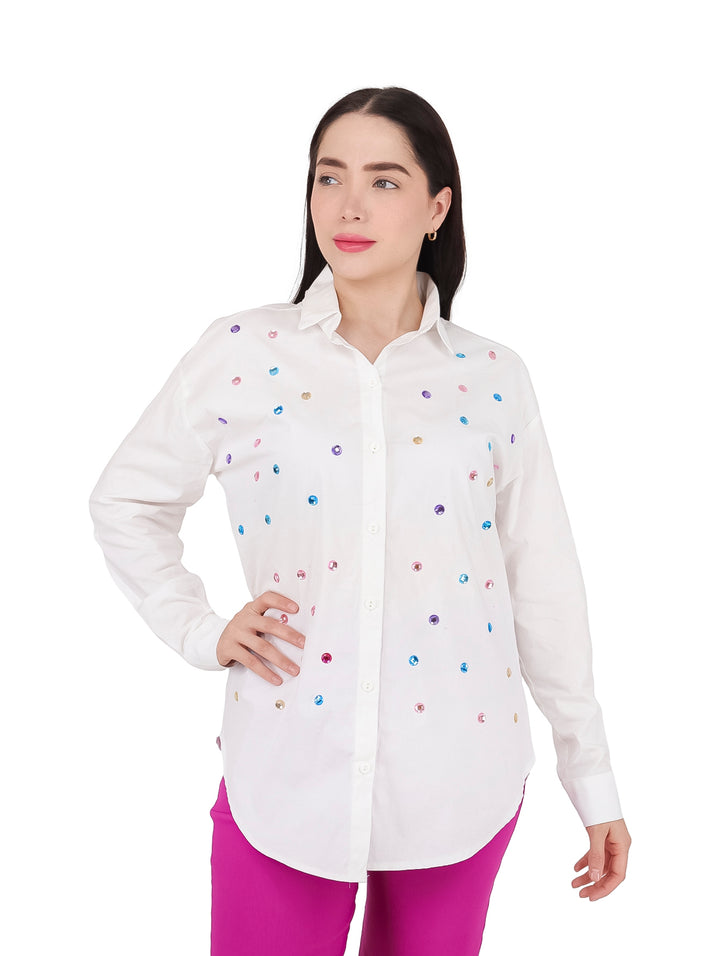 Mujer vistiendo camisa blanca de manga larga con perlas coloridas decorativas.