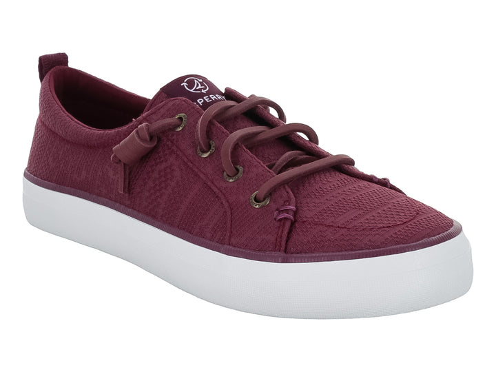 Tenis Sperry color vino con suela blanca y cordones coordinados.