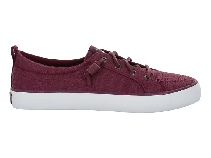 Tenis Sperry color vino con suela blanca y cordones coordinados.