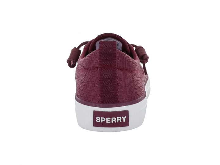 Tenis Sperry color vino con suela blanca y cordones coordinados.