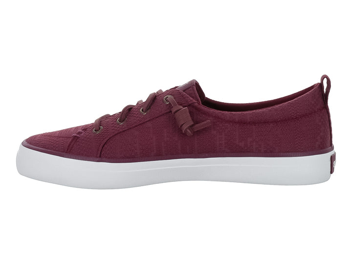 Tenis Sperry color vino con suela blanca y cordones coordinados.
