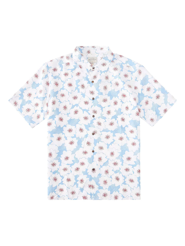 Camisa de manga corta color azul claro con estampado de flores blancas y centros rojos.