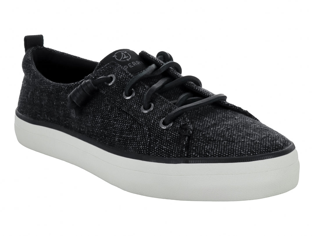 Tenis Sperry color negro de tela con suela blanca y cordones negros.