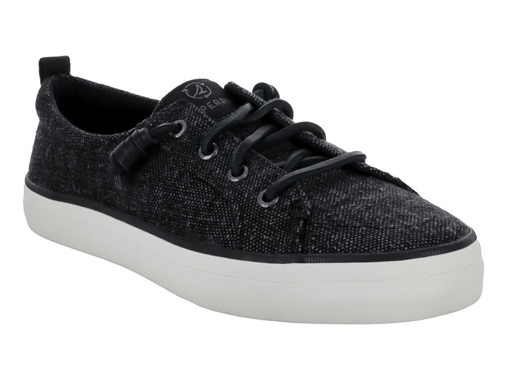 Tenis Sperry color negro de tela con suela blanca y cordones negros.