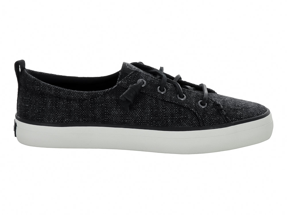Tenis Sperry color negro de tela con suela blanca y cordones negros.