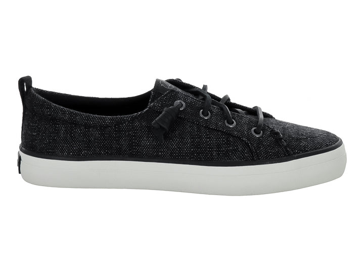 Tenis Sperry color negro de tela con suela blanca y cordones negros.