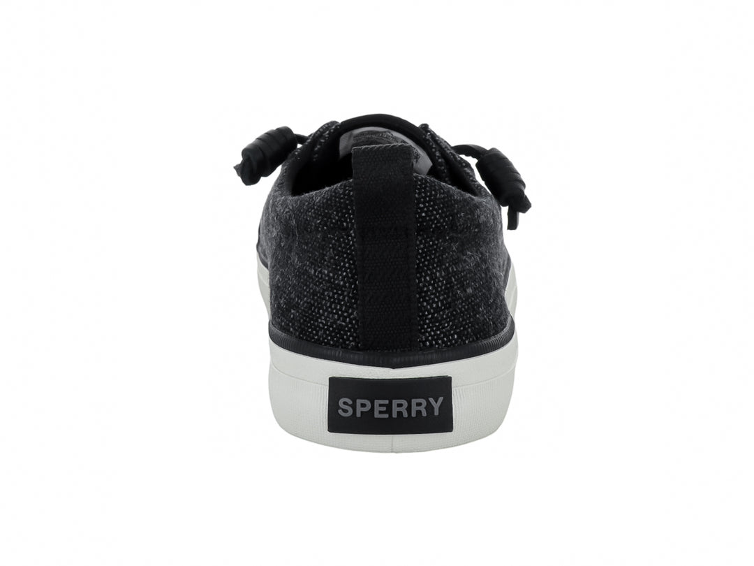 Tenis Sperry color negro de tela con suela blanca y cordones negros.
