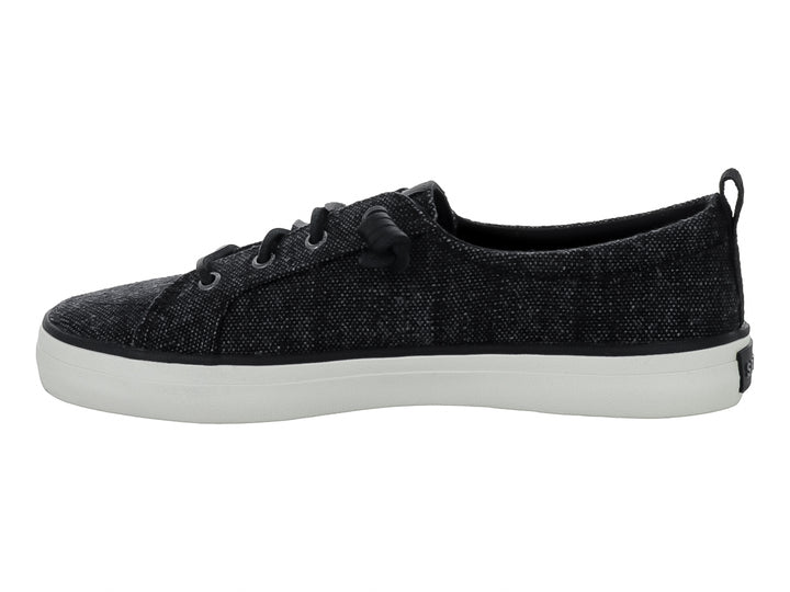 Tenis Sperry color negro de tela con suela blanca y cordones negros.
