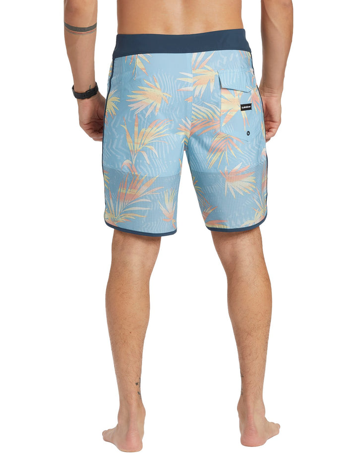 Traje de baño Quiksilver azul cielo con estampado de hojas tropicales y cintura azul marino.