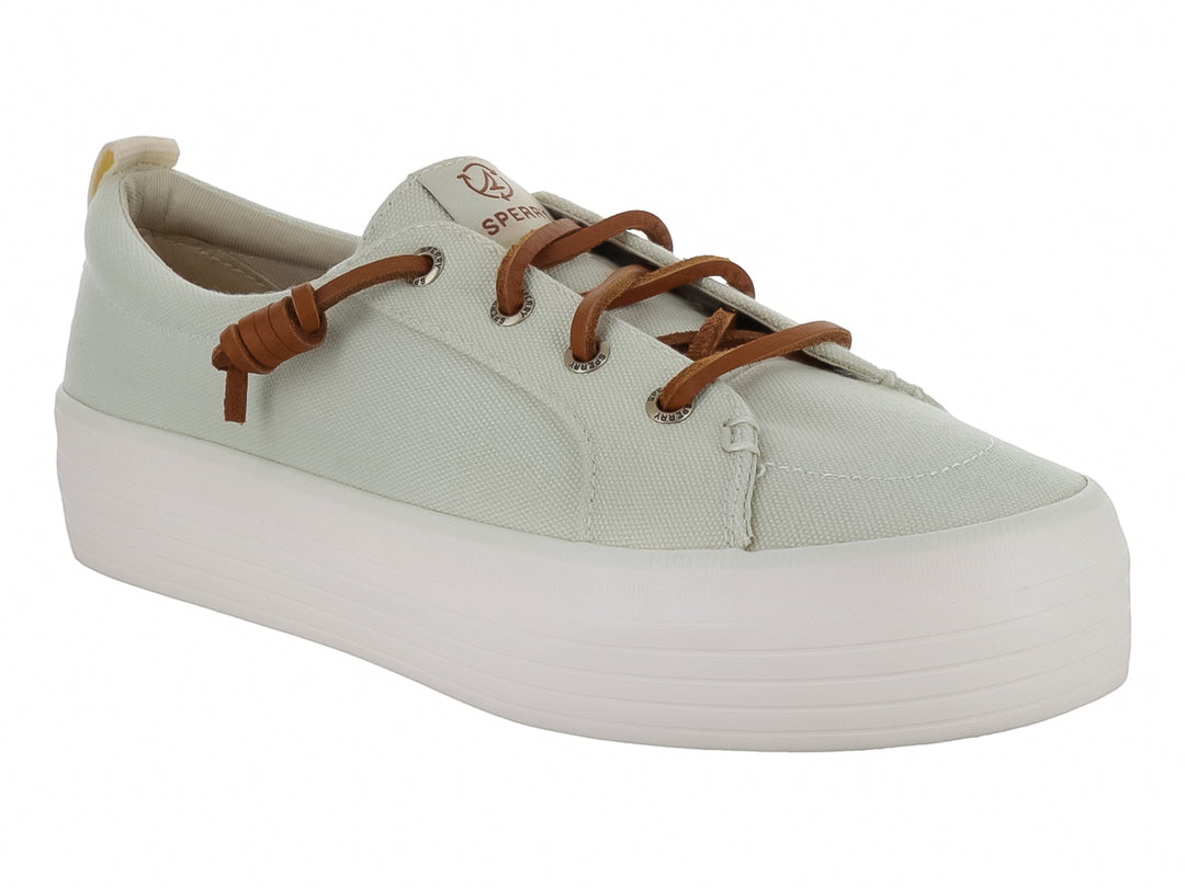 Tenis Sperry color blanco hueso con suela de plataforma blanca y cordones color café.