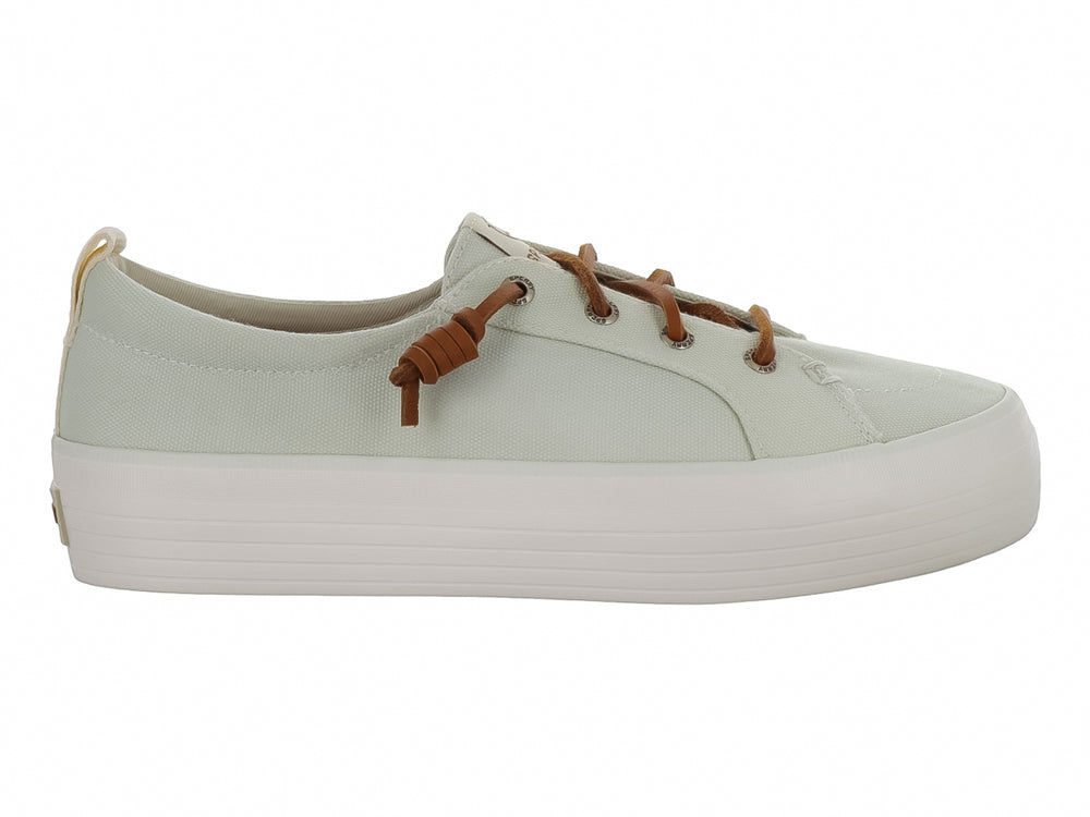 Tenis Sperry color blanco hueso con suela de plataforma blanca y cordones color café.