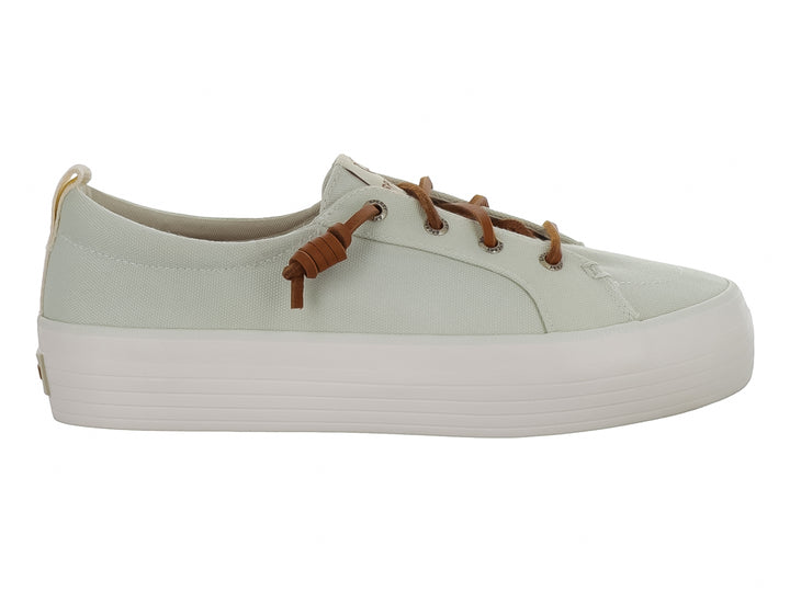 Tenis Sperry color blanco hueso con suela de plataforma blanca y cordones color café.