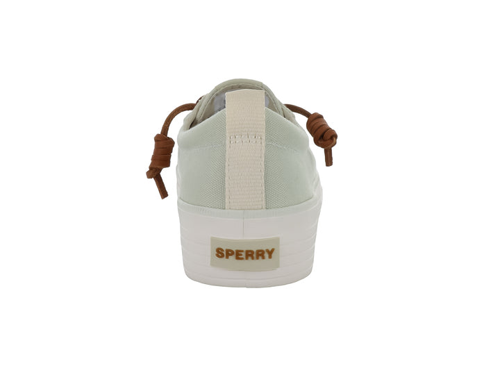 Tenis Sperry color blanco hueso con suela de plataforma blanca y cordones color café.
