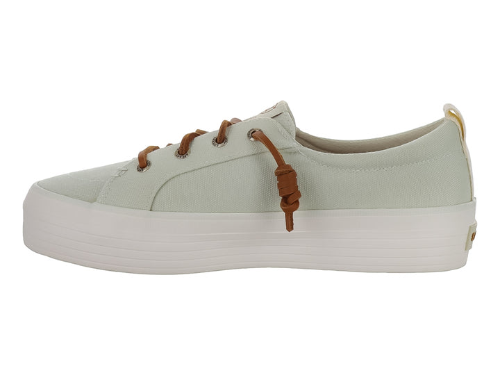 Tenis Sperry color blanco hueso con suela de plataforma blanca y cordones color café.