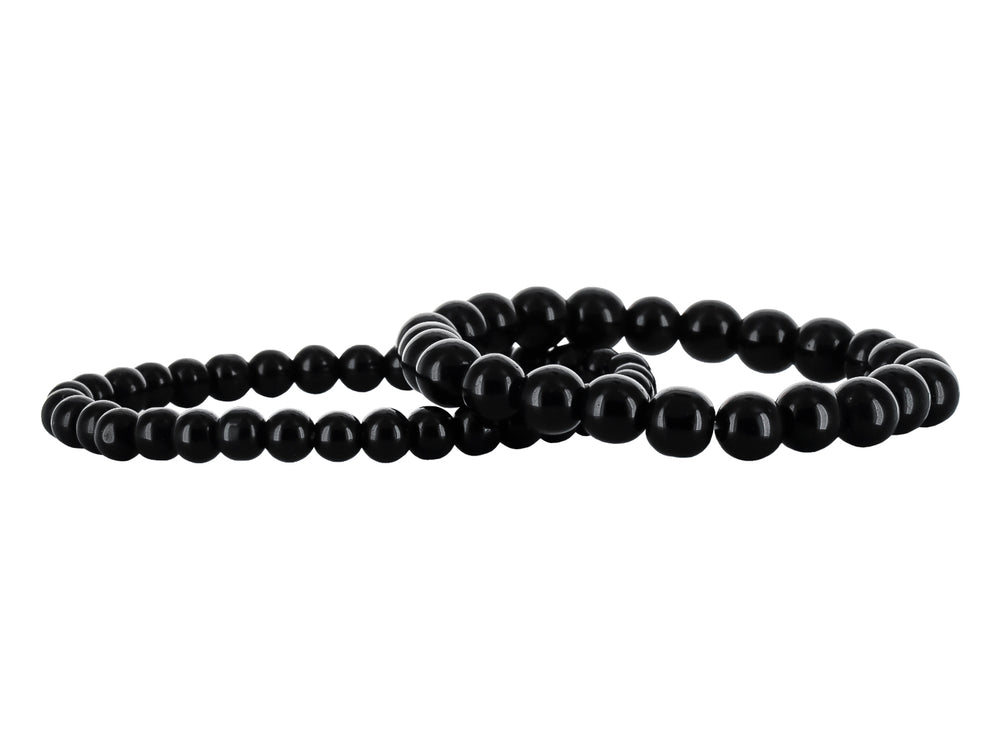 Pulsera de banda negra con placa central de metal plateado y cierre ajustable.