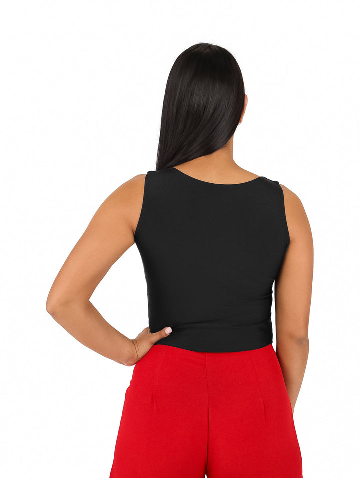 Mujer vistiendo una blusa negra sin mangas adornada con pequeñas piedras multicolores brillantes.