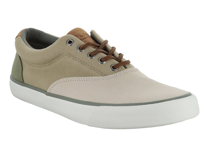 Zapatilla casual Sperry de lona color beige con suela blanca y cordones cafés.
