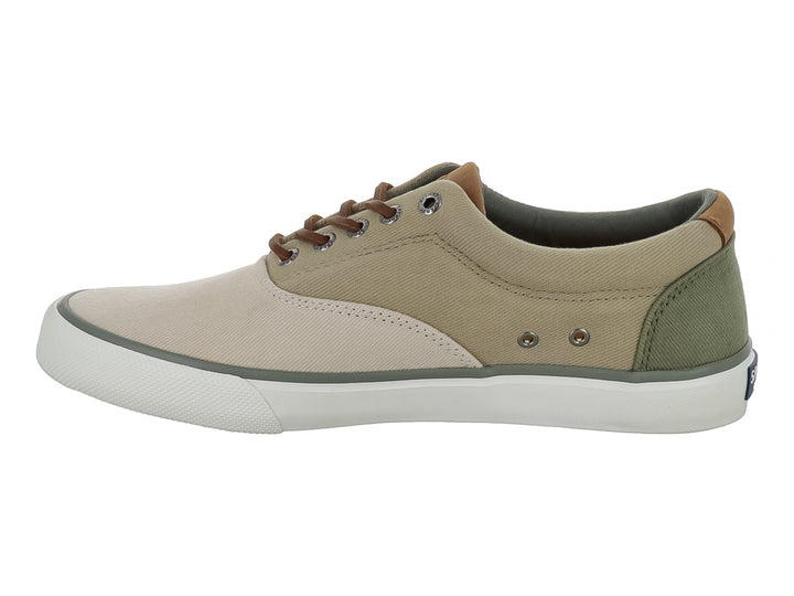 Zapatilla casual Sperry de lona color beige con suela blanca y cordones cafés.