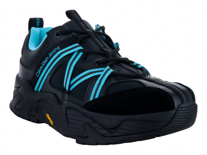 Tenis deportivos Calvin Klein color negro con detalles en azul claro y suela gruesa Vibram.