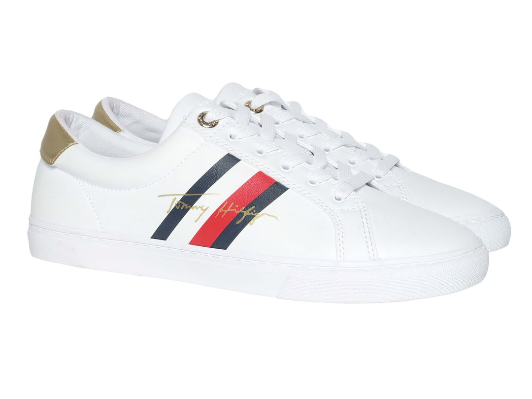 Tenis blancos de Tommy Hilfiger con detalle dorado en el talón y suela blanca.