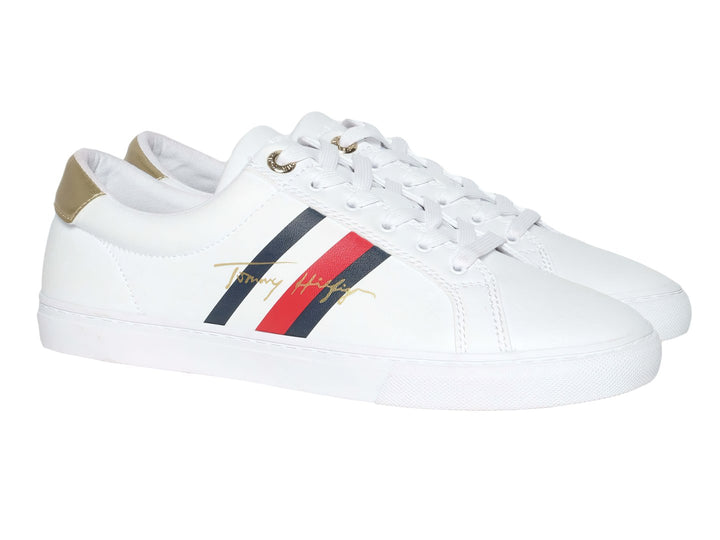 Tenis blancos de Tommy Hilfiger con detalle dorado en el talón y suela blanca.