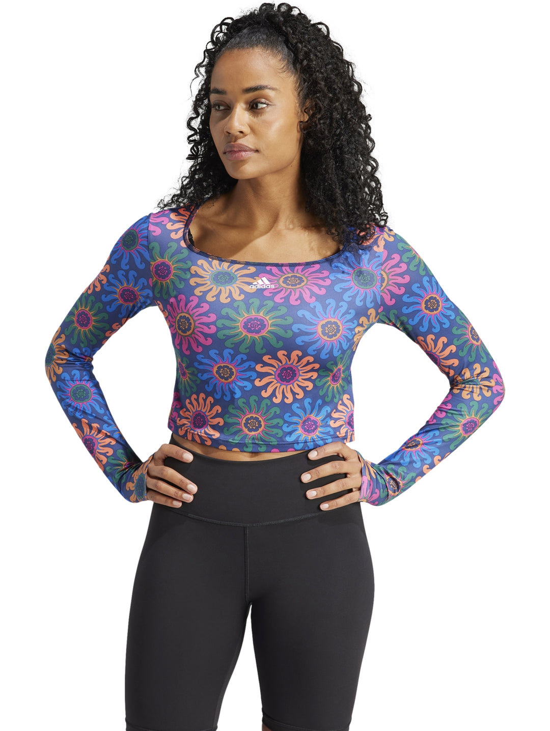 Crop top deportivo de manga larga con estampado floral multicolor sobre fondo azul oscuro.