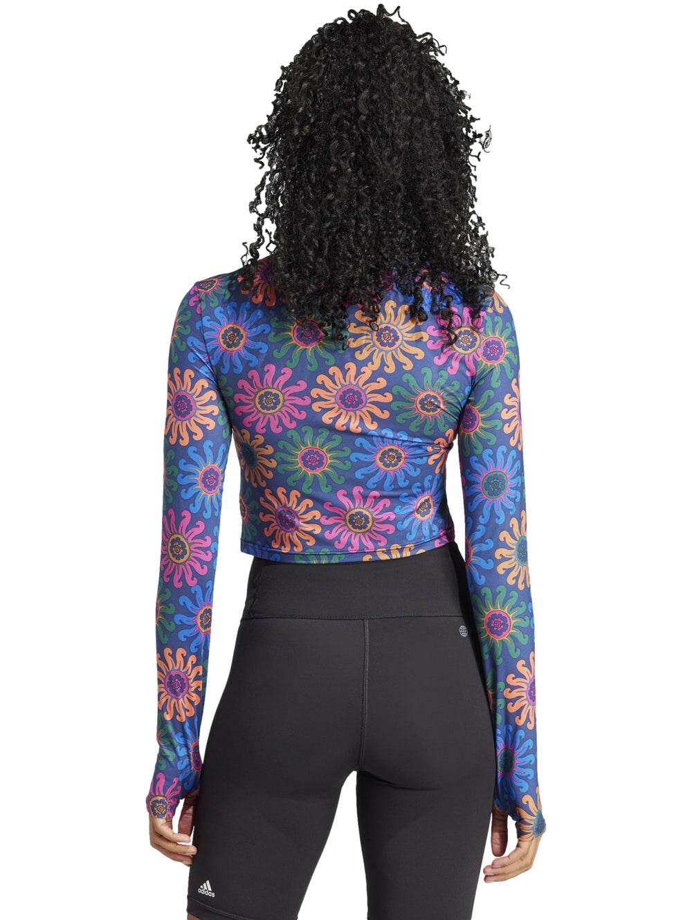 Crop top deportivo de manga larga con estampado floral multicolor sobre fondo azul oscuro.