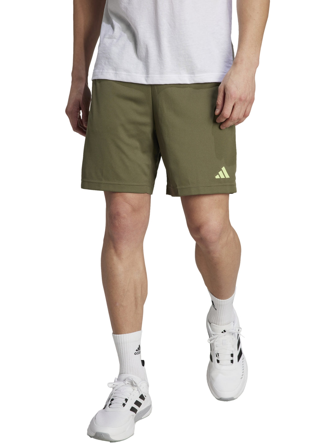 Hombre vistiendo shorts deportivos Adidas en color verde oliva con logo en contraste.