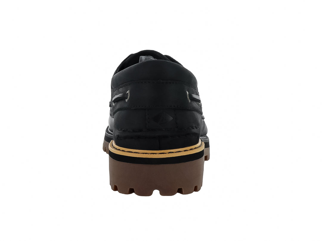 Zapato náutico Sperry de cuero negro con suela track marrón y costuras contrastantes.