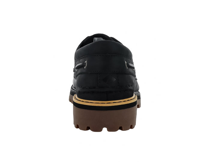 Zapato náutico Sperry de cuero negro con suela track marrón y costuras contrastantes.