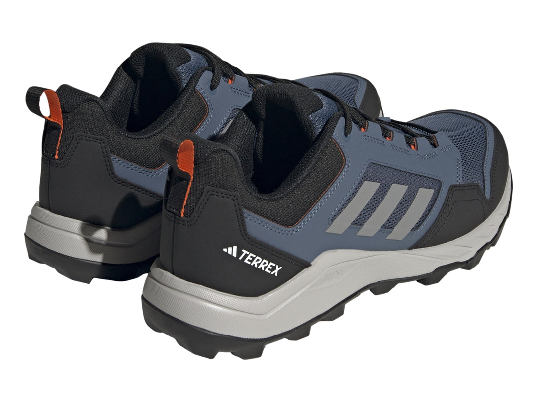 Tenis Adidas Terrex color azul marino y gris con detalles naranja y suela para senderismo.
