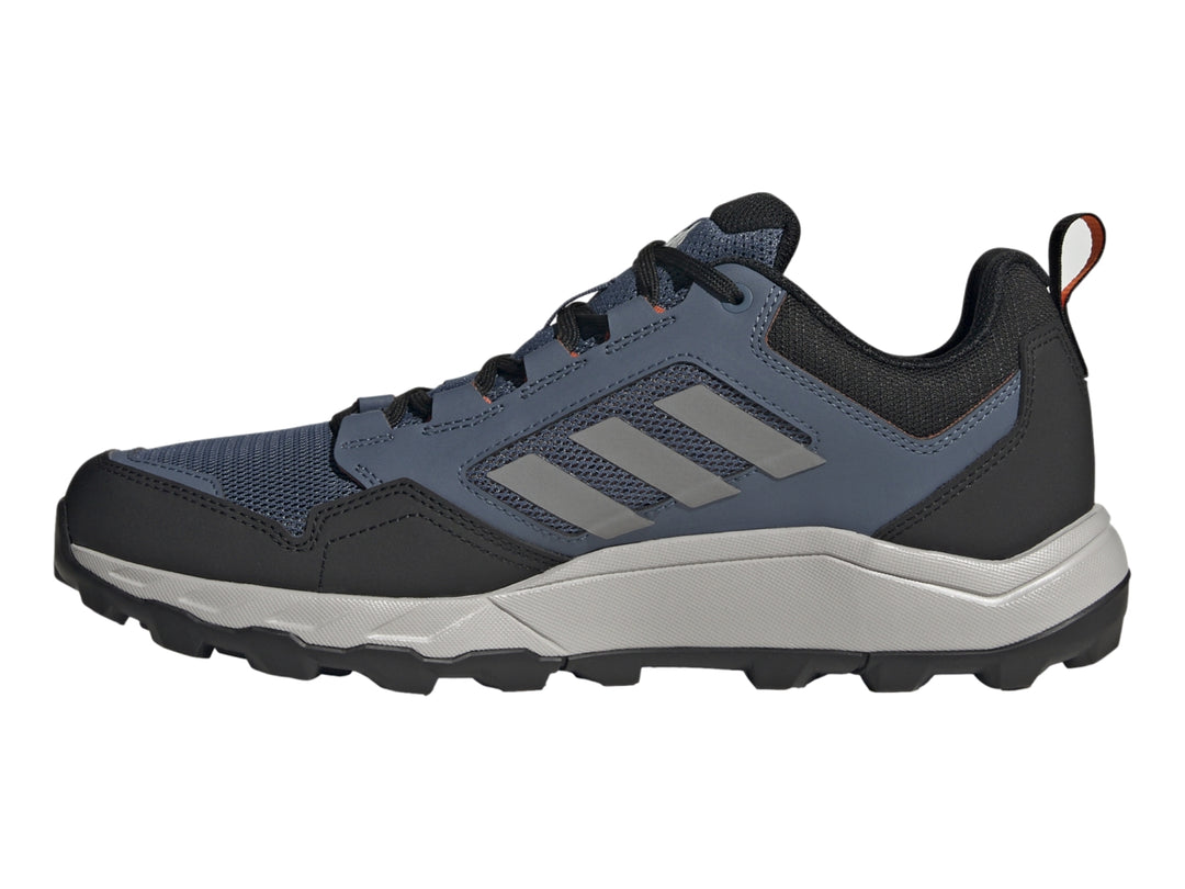 Tenis Adidas Terrex color azul marino y gris con detalles naranja y suela para senderismo.