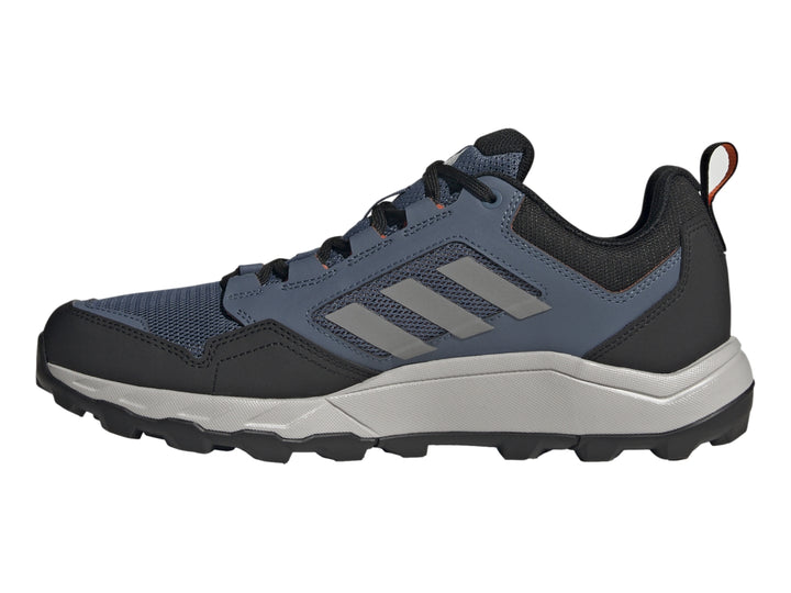 Tenis Adidas Terrex color azul marino y gris con detalles naranja y suela para senderismo.