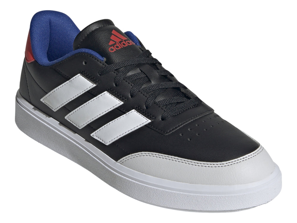 Tenis Adidas Courtblock color negro con tres franjas blancas, suela blanca y detalles en azul y rojo en el talón.