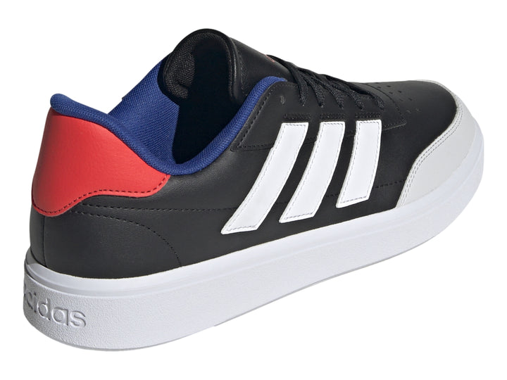 Tenis Adidas Courtblock color negro con tres franjas blancas, suela blanca y detalles en azul y rojo en el talón.