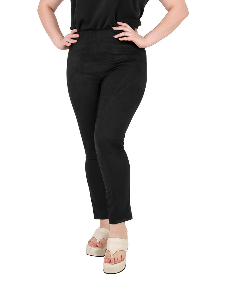 Mujer vistiendo leggings negros de textura mate y sandalias blancas de plataforma.