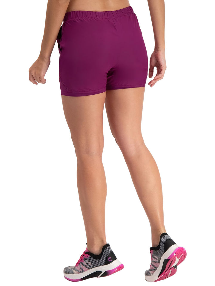 Mujer vistiendo shorts deportivos de color rosa oscuro con cintura elástica.