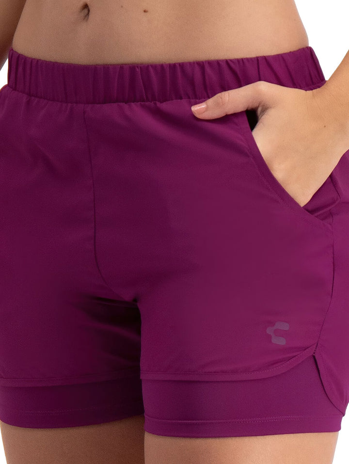 Mujer vistiendo shorts deportivos de color rosa oscuro con cintura elástica.