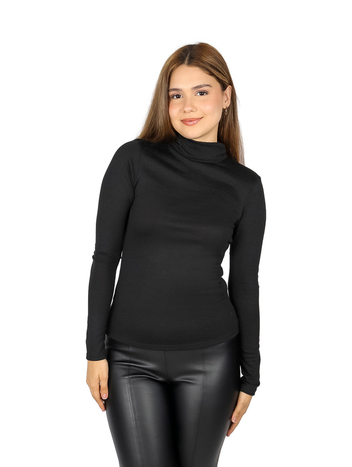 Mujer vistiendo blusa negra de manga larga y cuello alto.
