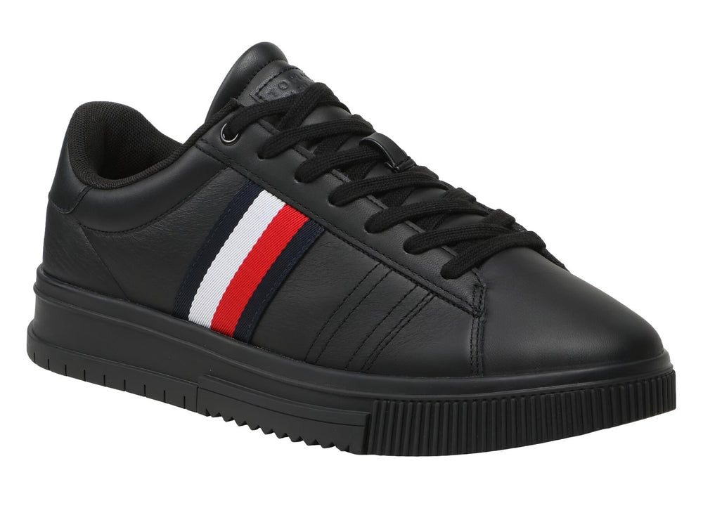 Tenis Tommy Hilfiger de cuero negro con franja tricolor lateral y suela negra.