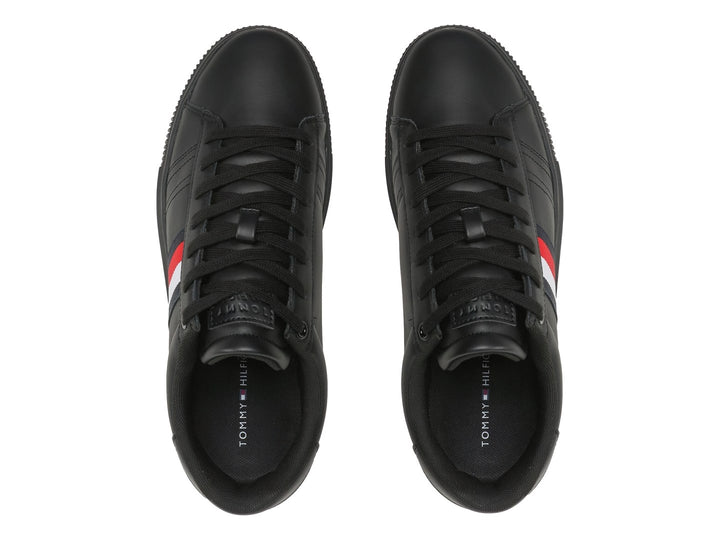 Tenis Tommy Hilfiger de cuero negro con franja tricolor lateral y suela negra.