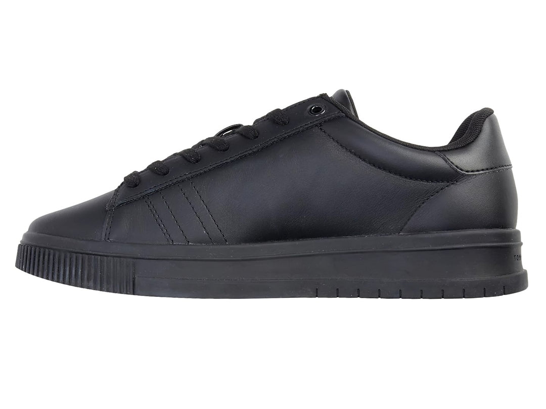 Tenis Tommy Hilfiger de cuero negro con franja tricolor lateral y suela negra.