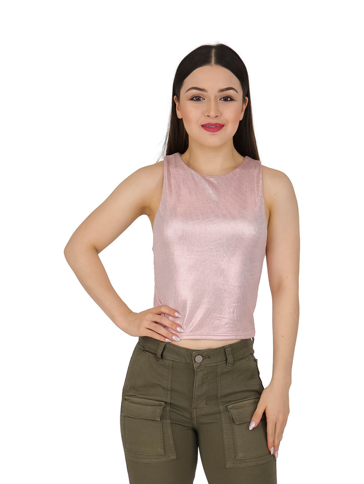 Mujer vistiendo una blusa rosa metálica sin mangas y pantalones cargo color verde oliva.