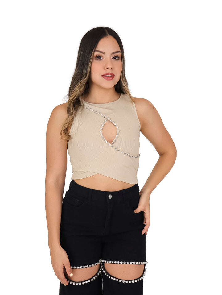 Blusa beige sin mangas con detalle de cut-out frontal y adornos de pedrería blanca.