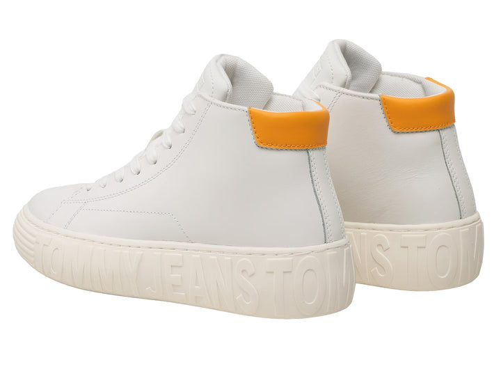Tenis blancos de caña alta con detalle naranja en el talón y letras en relieve en la suela.