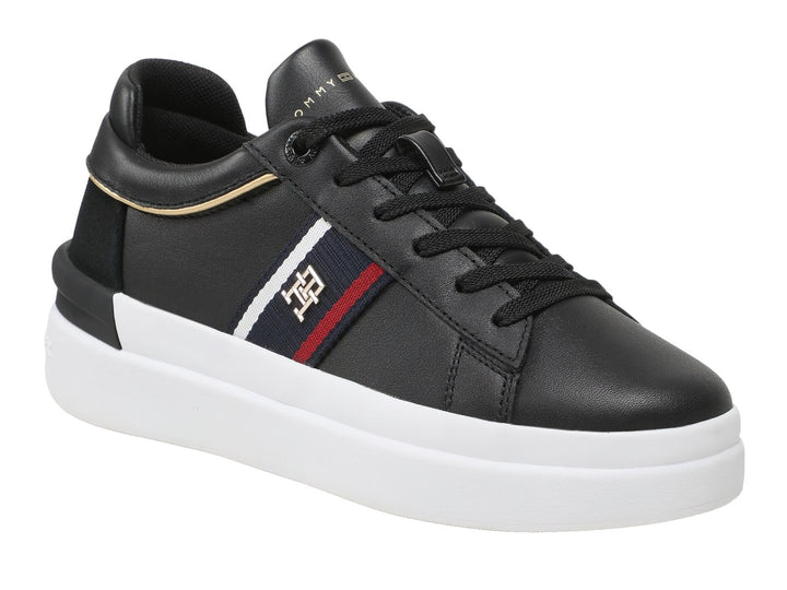 Tenis Tommy Hilfiger negros con suela blanca y detalle de cinta tricolor en el lateral.