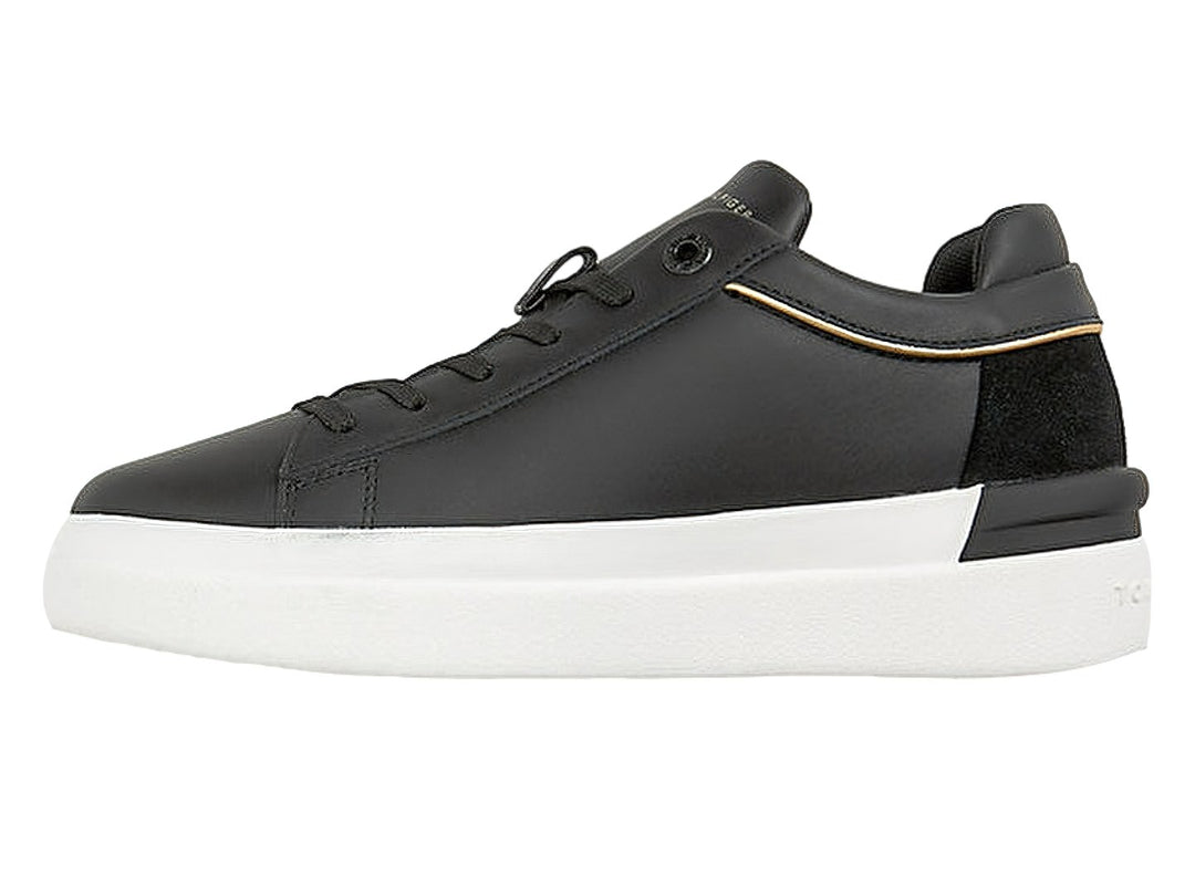 Tenis Tommy Hilfiger negros con suela blanca y detalle de cinta tricolor en el lateral.