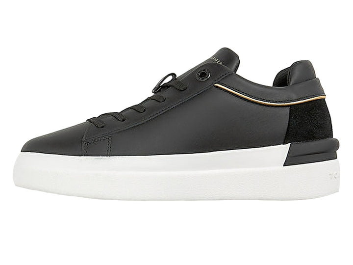 Tenis Tommy Hilfiger negros con suela blanca y detalle de cinta tricolor en el lateral.