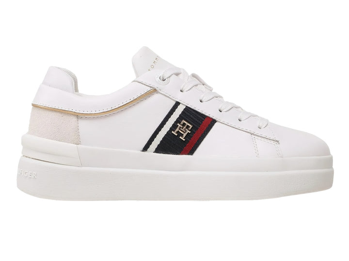 Tenis blancos Tommy Hilfiger de corte bajo con franja lateral tricolor y detalle beige en el talón.