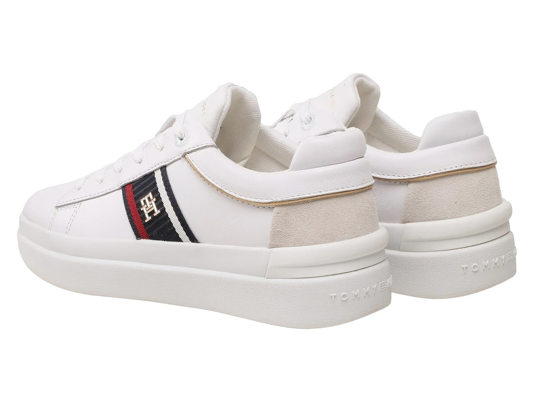 Tenis blancos Tommy Hilfiger de corte bajo con franja lateral tricolor y detalle beige en el talón.